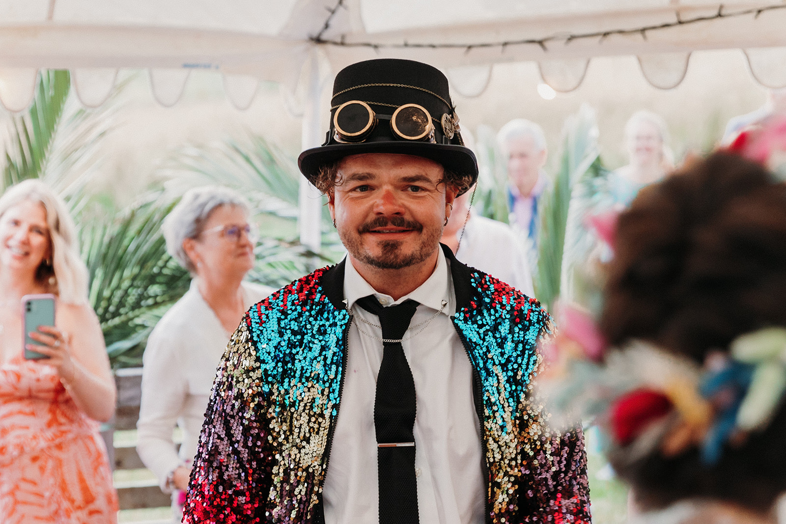 groom wears colourful sequin jacket and vintage bucket hat