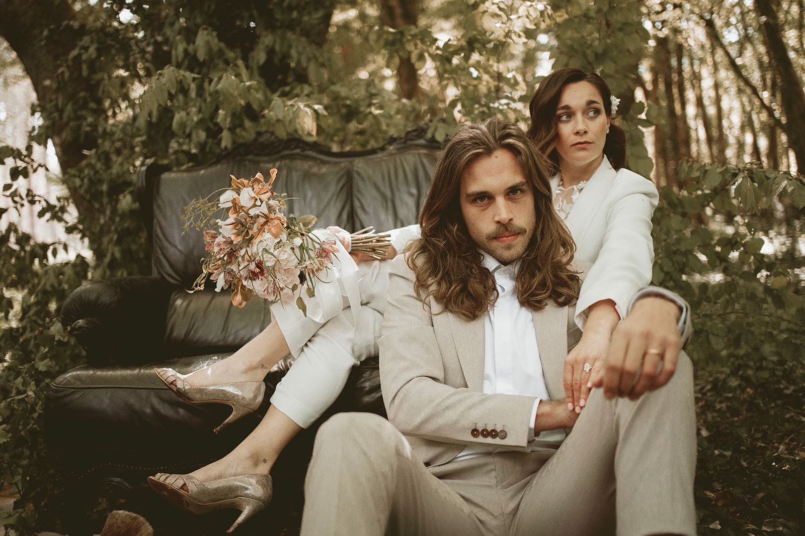 bride and groom sitting on sofa in woodland wedding ceremony