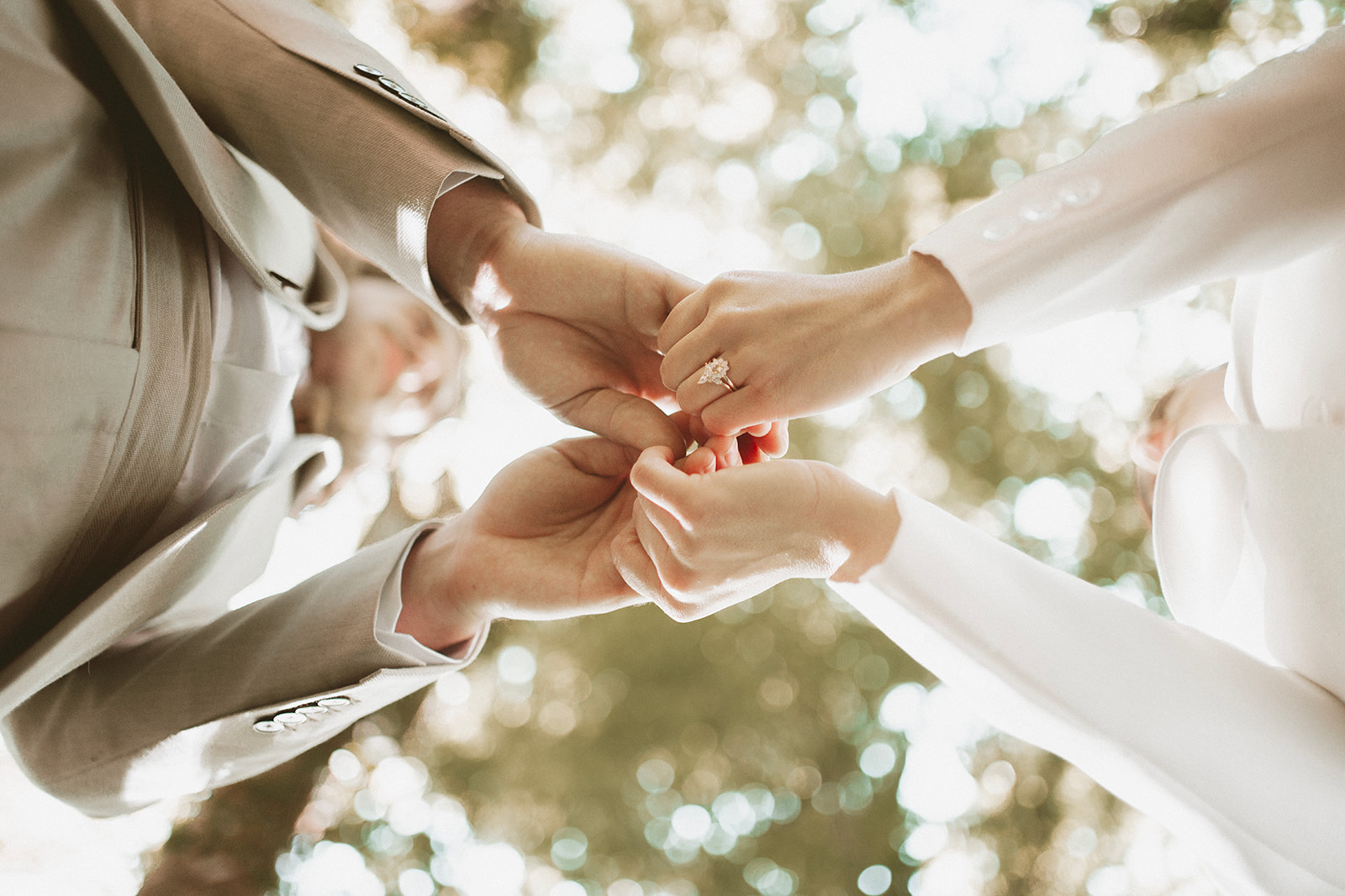 artistic wedding photo of bride and groom holding hands at woodland wedding