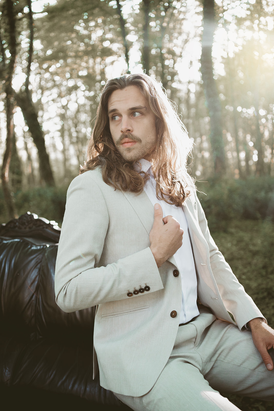 groom wearing cream suit in outdoor wedding