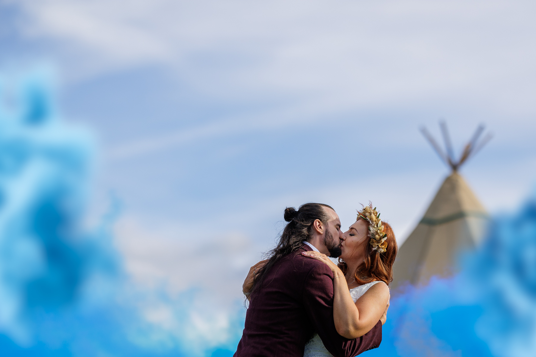 smoke bomb wedding photo of bride and groom kissing