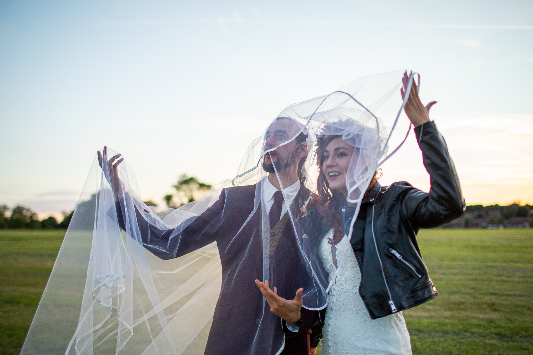 funny wedding photo of bride and groom tangled up in wedding veil