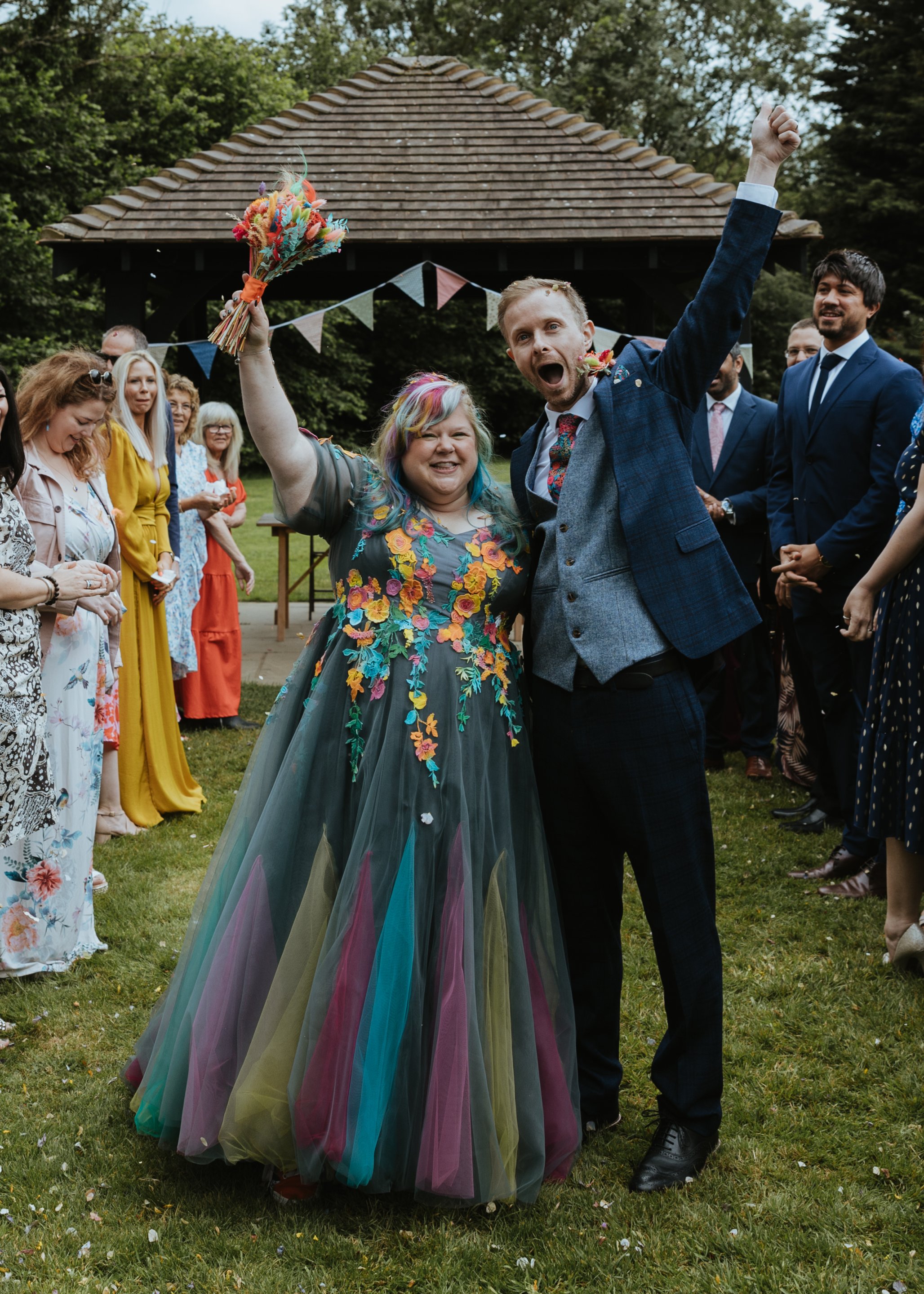 bride and groom with their arms in the air at their outdoor wedding ceremony