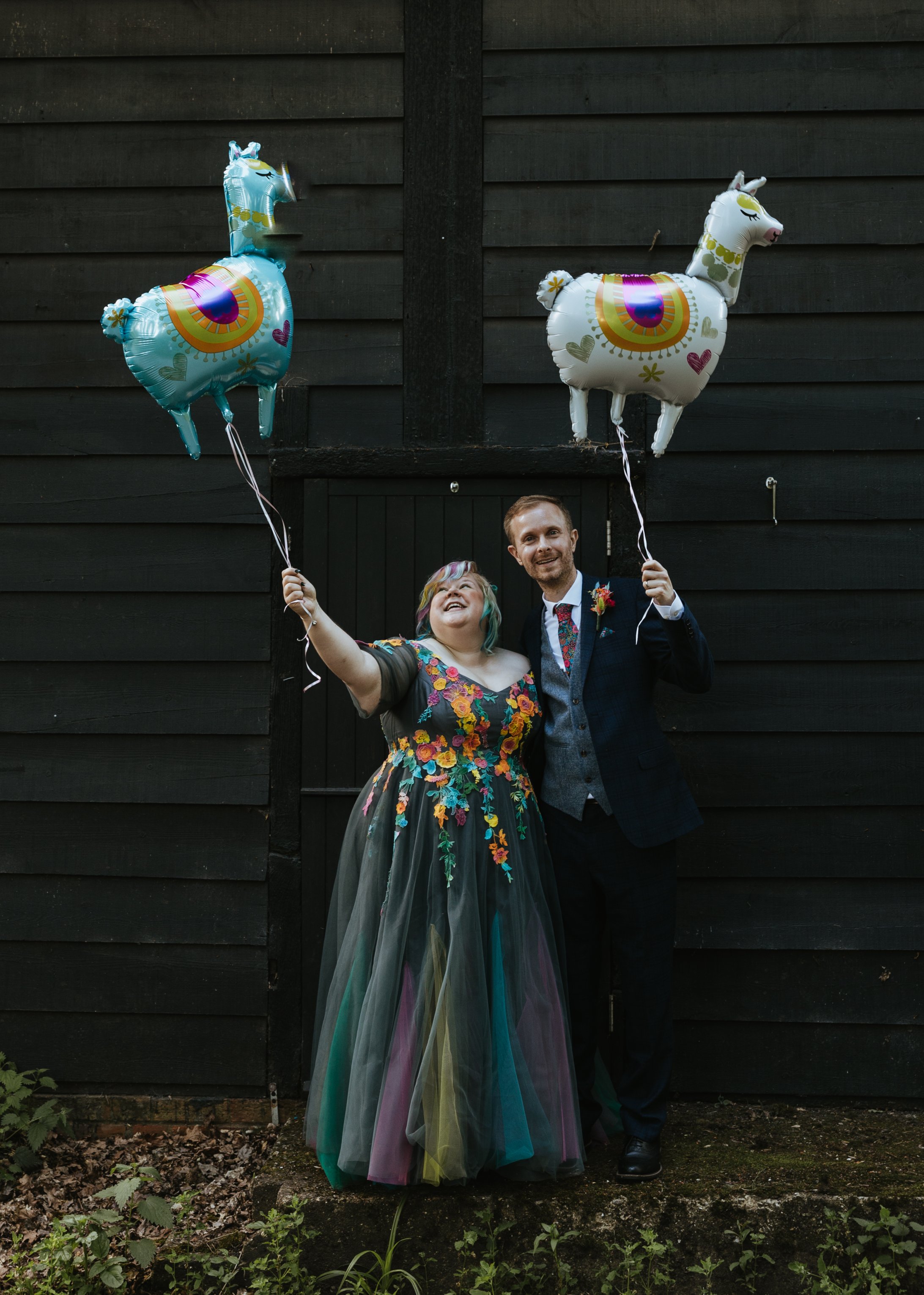bride and groom holding novelty balloons on unique wedding day