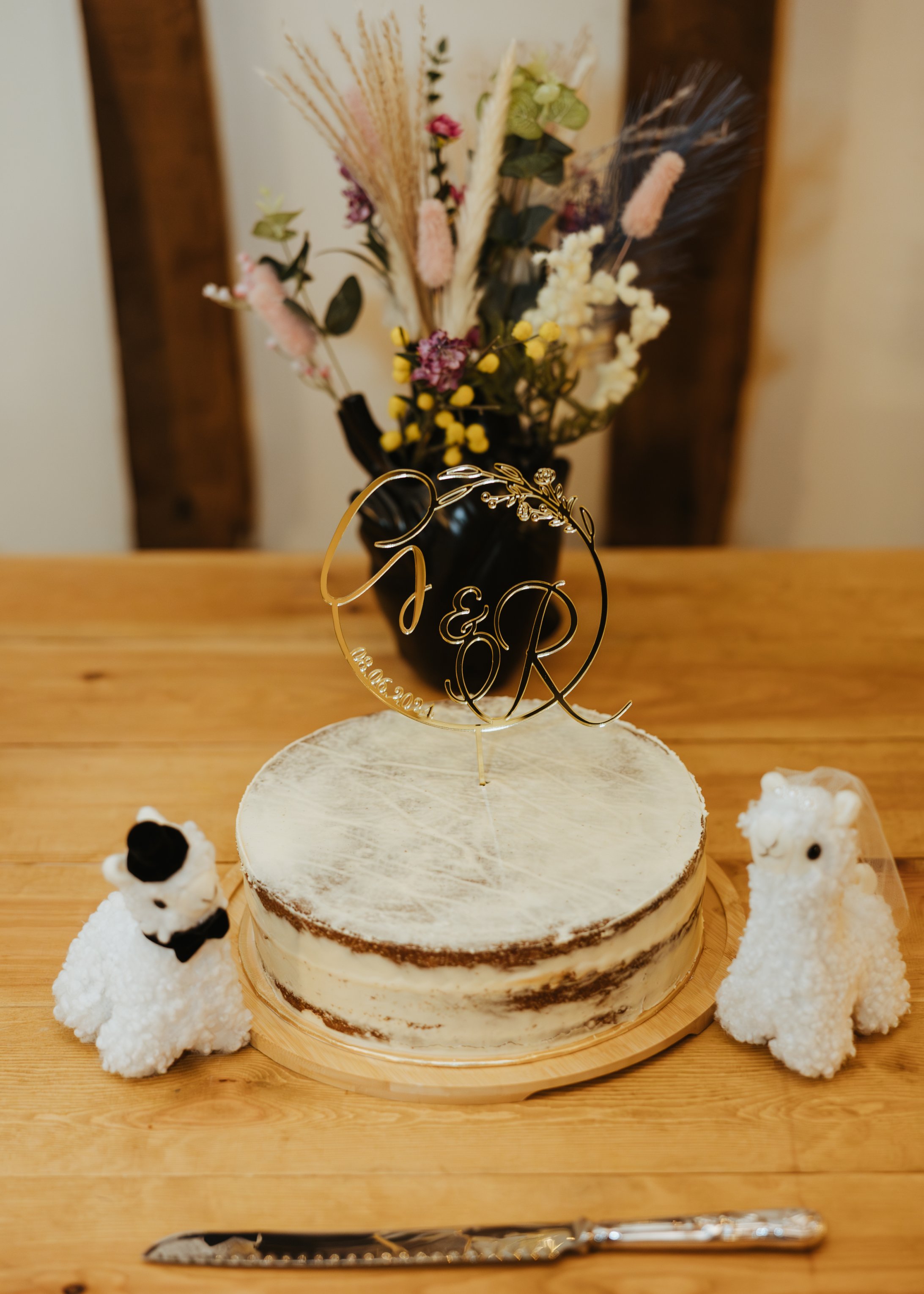 mini wedding cake next to stuffed toy alpacas