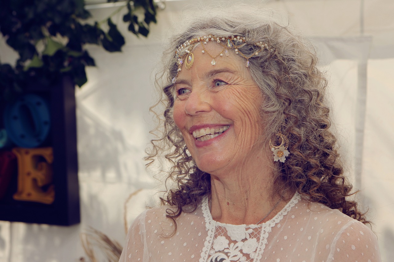 mature bride wearing a bohemian bridal headpiece and floral earrings