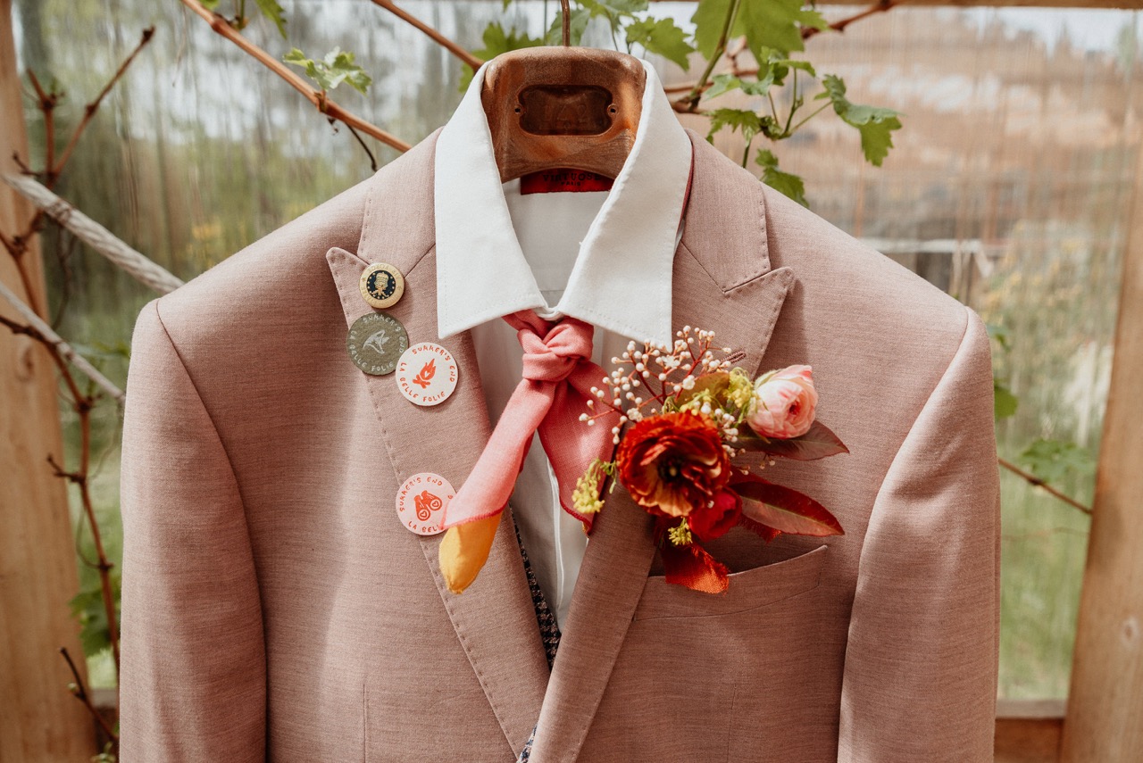 pink suit with neck tie and scout badges for summer camp wedding - wes anderson wedding