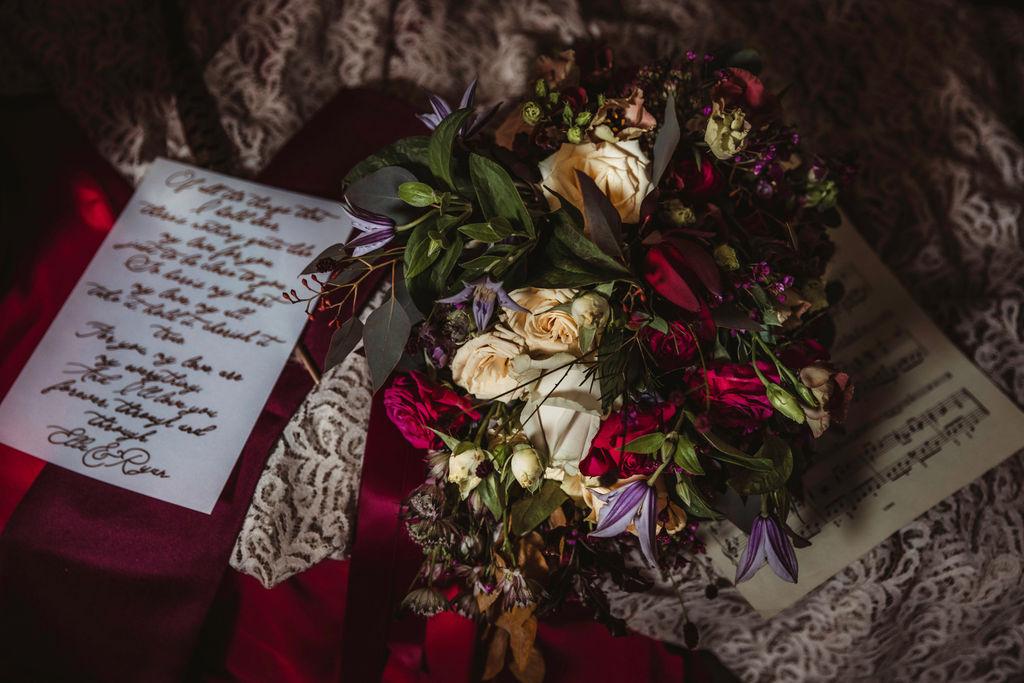 red, white and purple wedding bouquet with dark green foliage