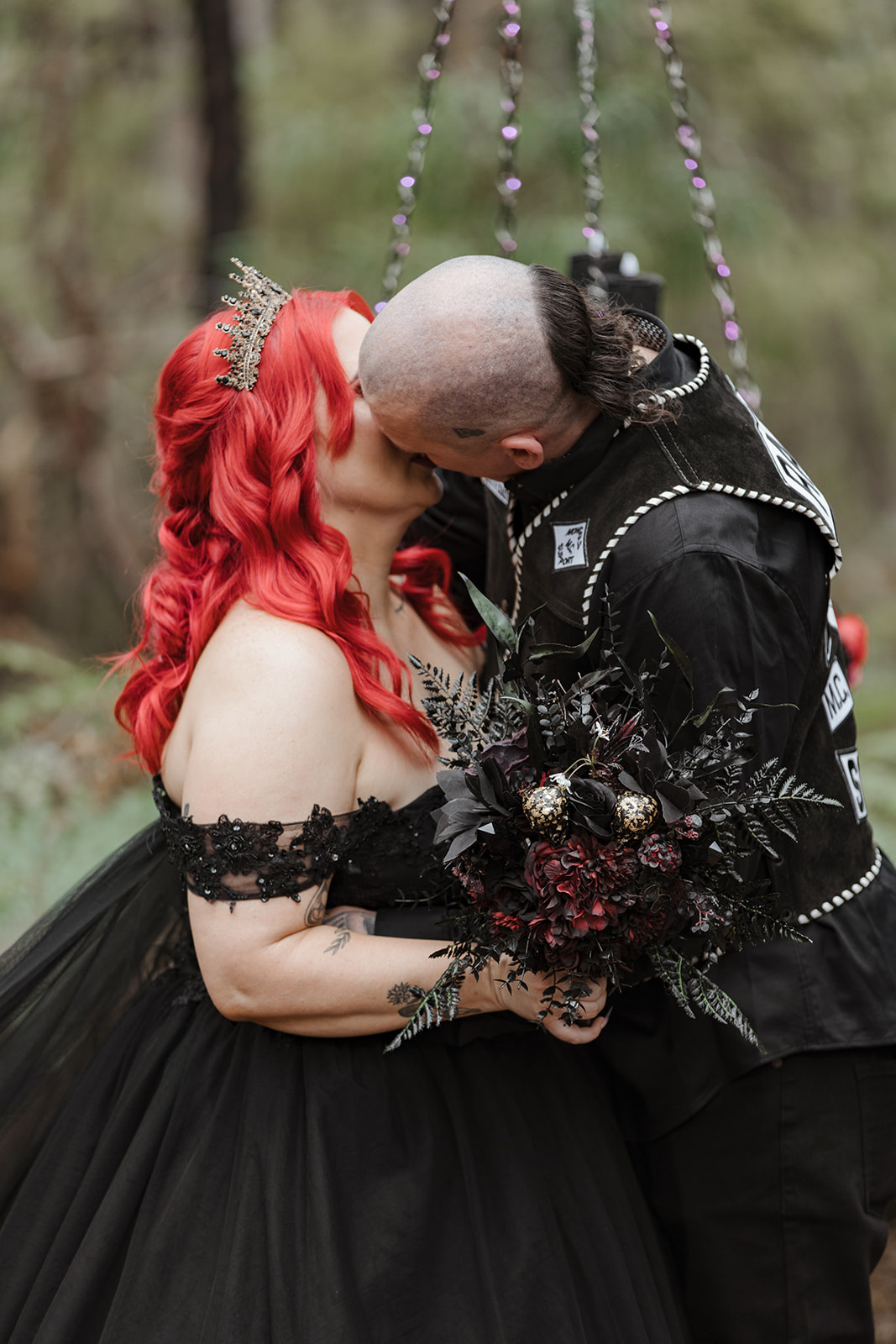gothic bride and groom kissing at their pagan wedding ceremony