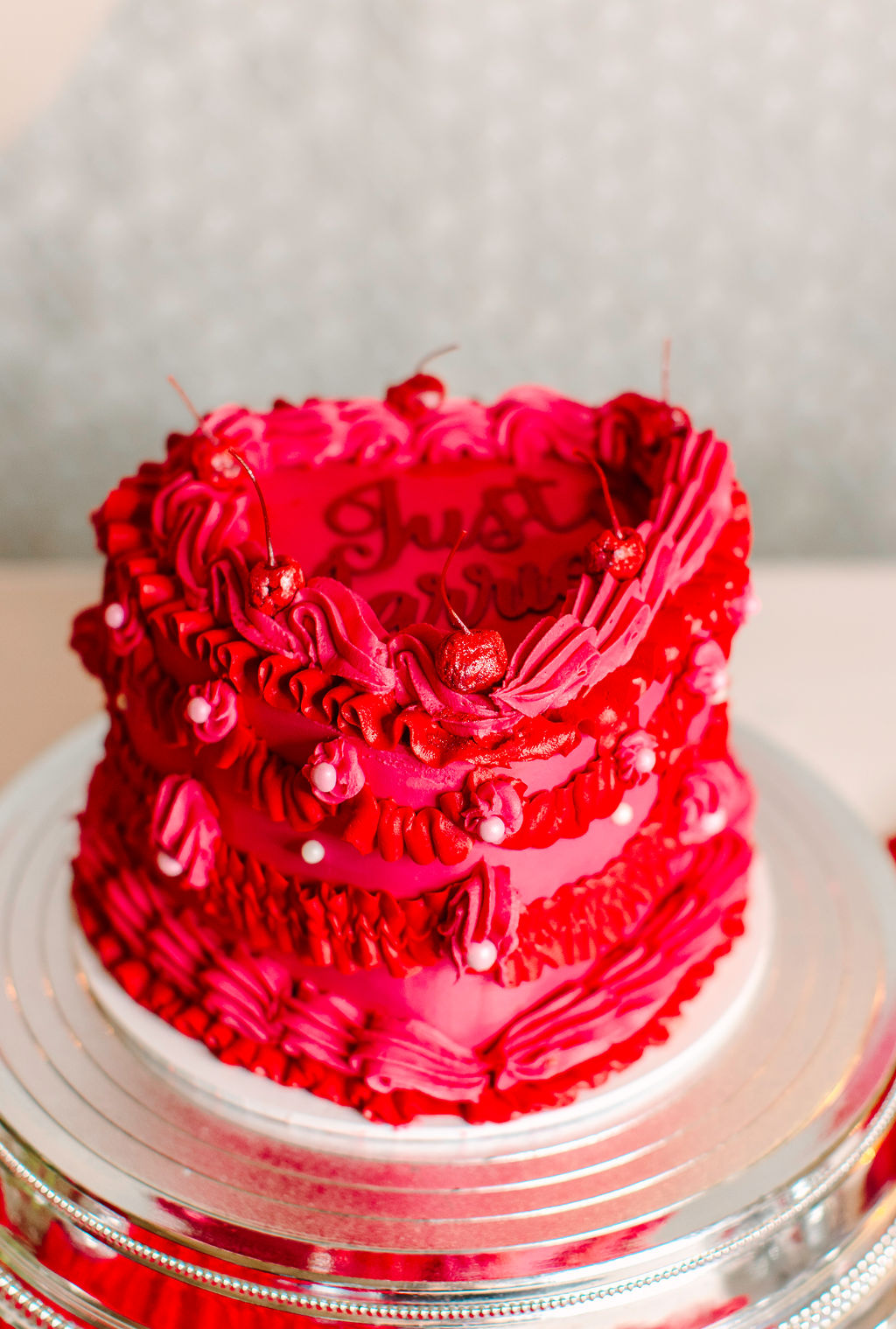 close up of pink and red retro love heart wedding cake which has 'just married' written on the top