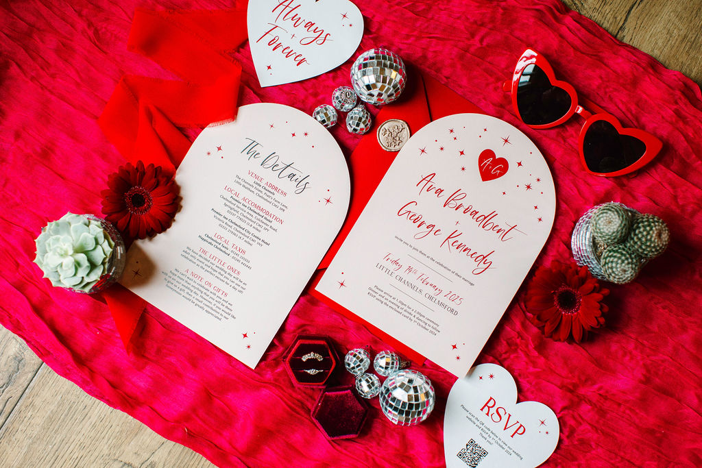 Pink and red love heart inspired wedding stationery for fun valentines wedding celebration. Glitter balls and bridal sunglasses feature around the stationery suit