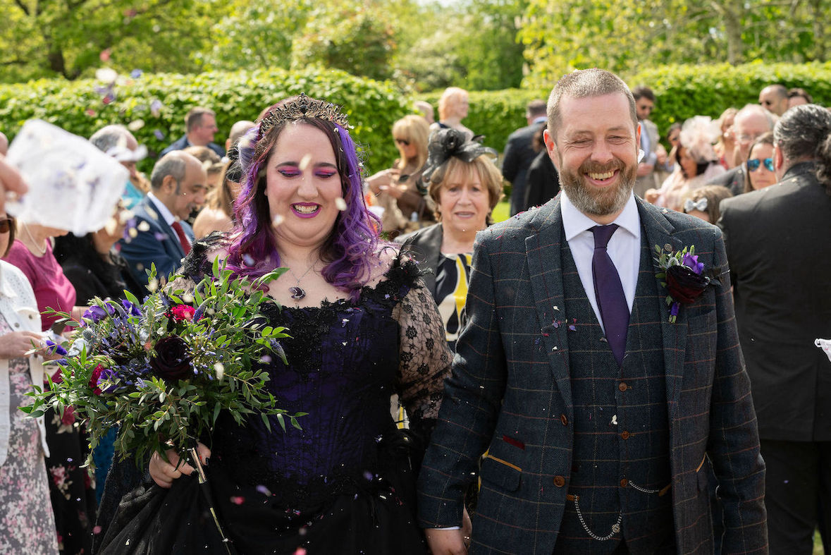 Bride and groom walking down the aisle after the wedding with confetti being thrown