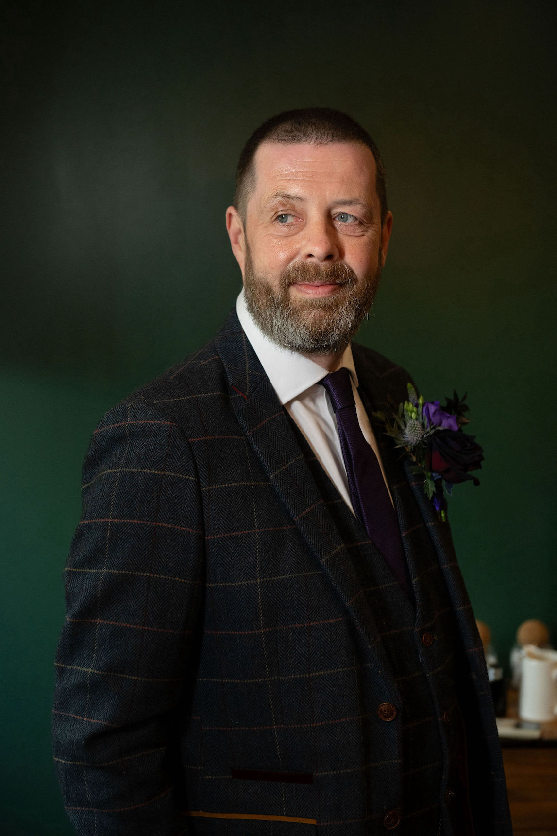 Groom wearing navy blue wedding suit with lego and flower buttonhole