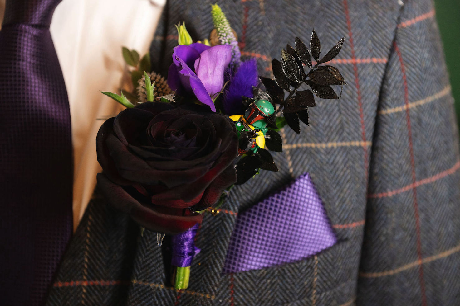 Close up of groom's pocket square and floral button hole with Star Wars Lego man