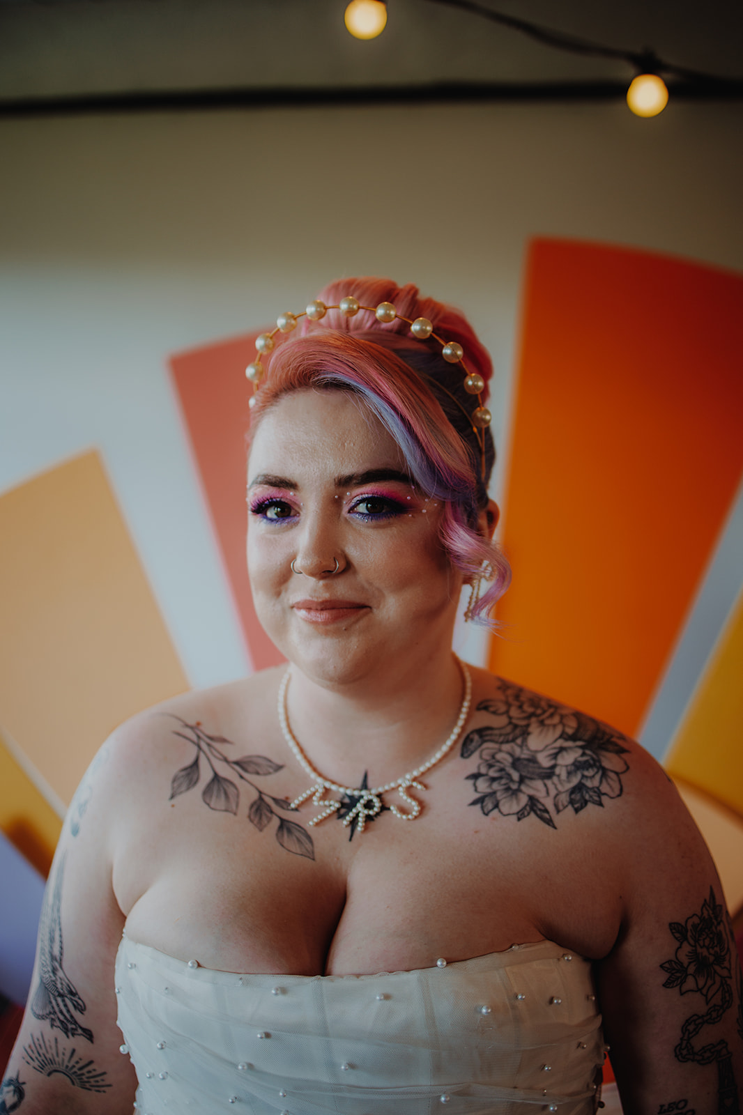 Close up of bride with pink and lilac hair wearing pearl halo crown and pearl MRS necklace to coordinate with her pearl bodice wedding dress