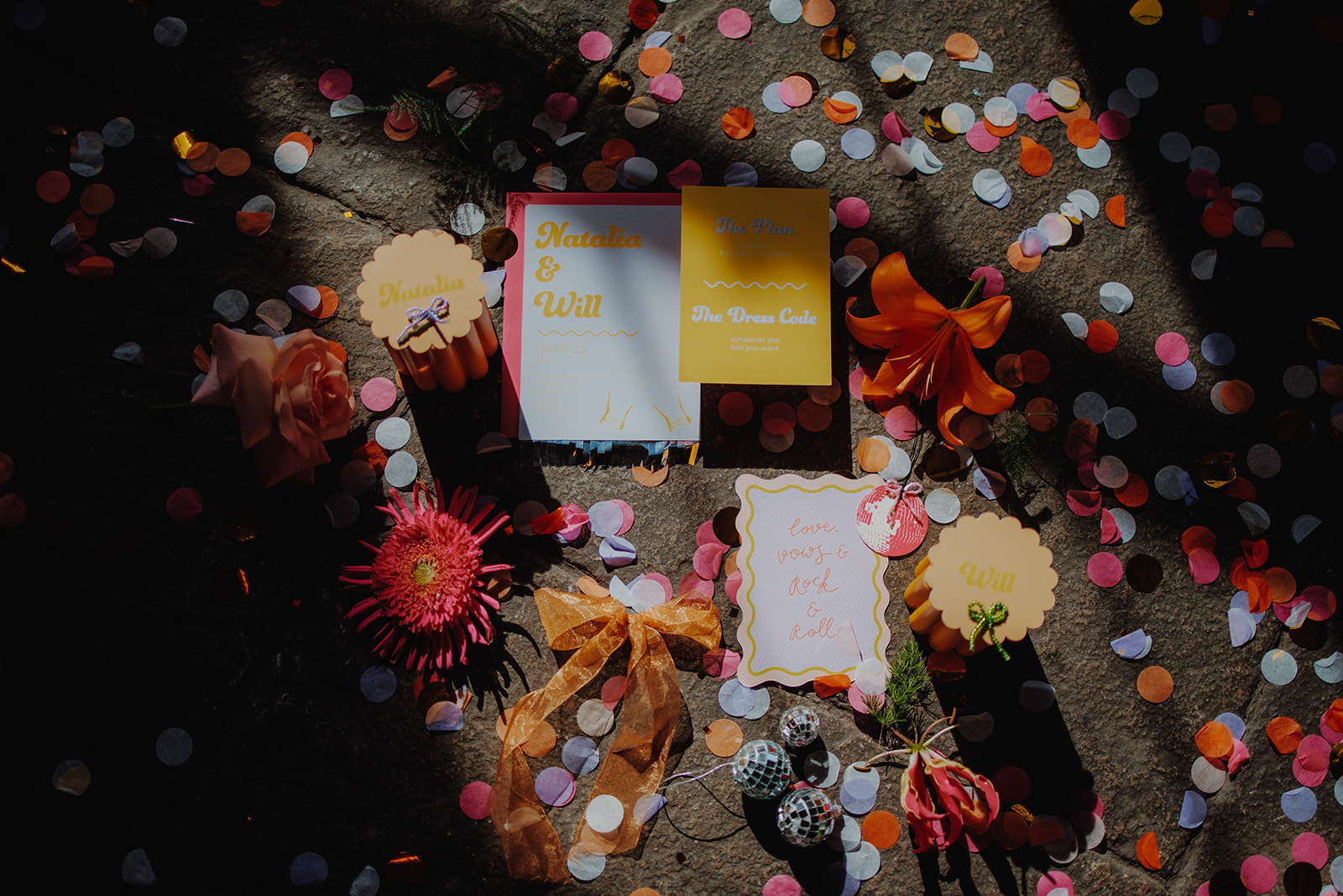 vibrant colourful wedding stationery flat lay with colourful confetti around