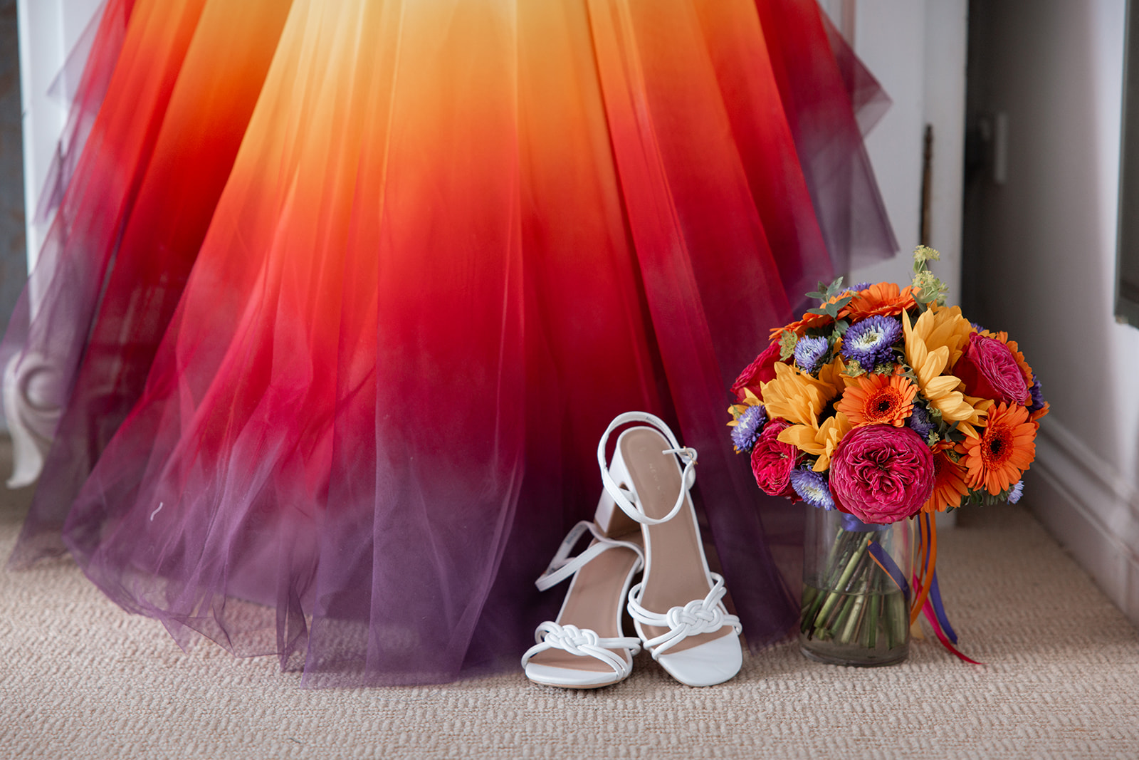close up of coordinating wedding bouquet and alternative colourful dip dye dress
