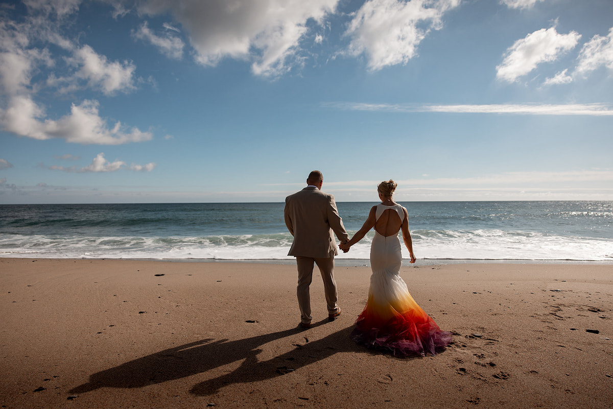 bride and groom holding hands on a sandy beach for couple portrait