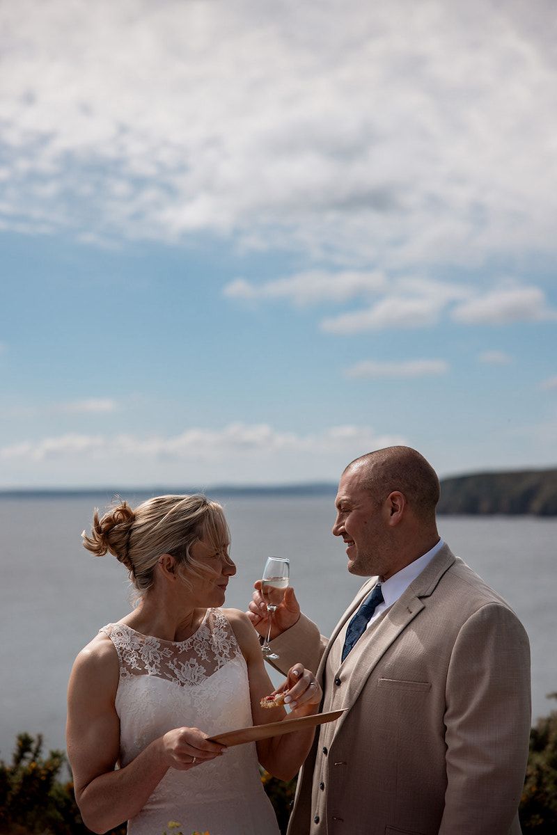 Bride eating scones with jam and cream while the groom drinks champagne