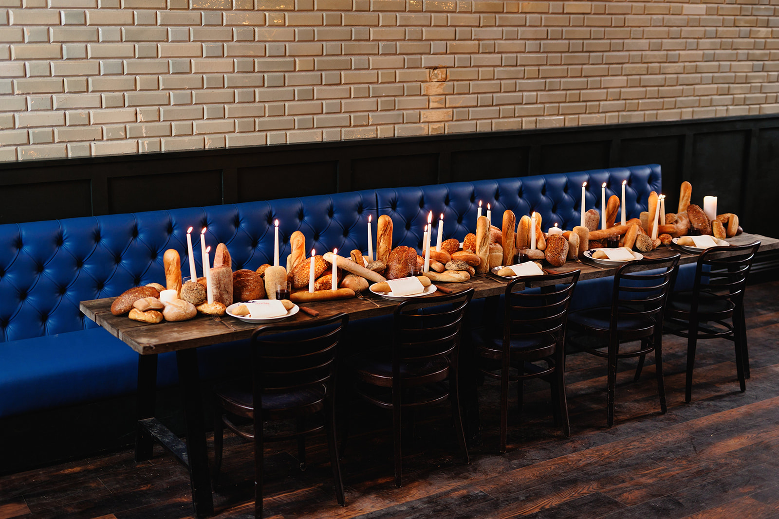 shot of the alternatively styled wedding breakfast table which features a centre piece of bread and candles.