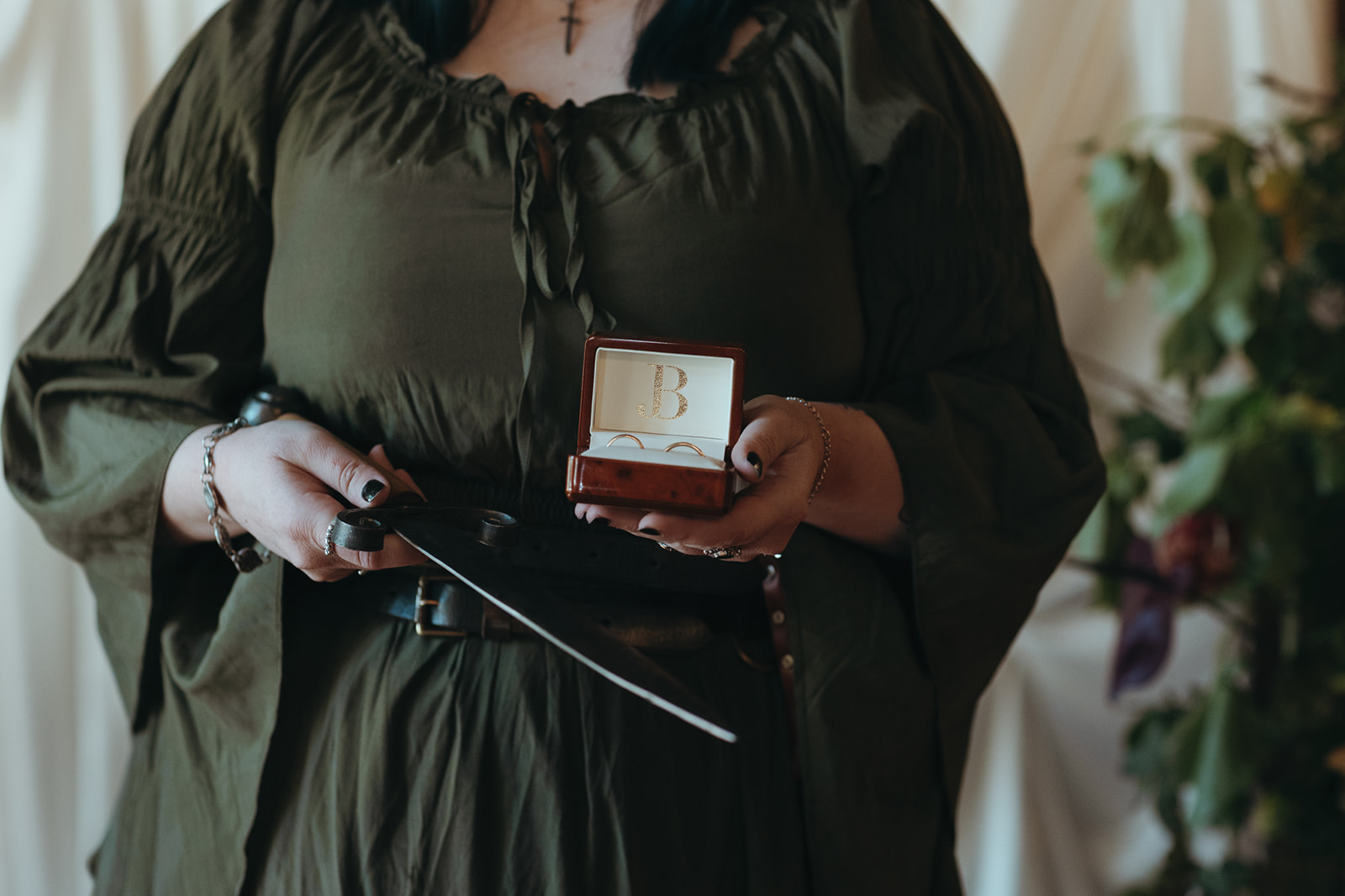 wedding celebrant holding a box with two wedding rings and a sword for presentation