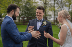 Northampton wedding magician and wedding host revilo twist, performs magic tricks on wedding guests. Bride and groom laugh and smile in amazement.