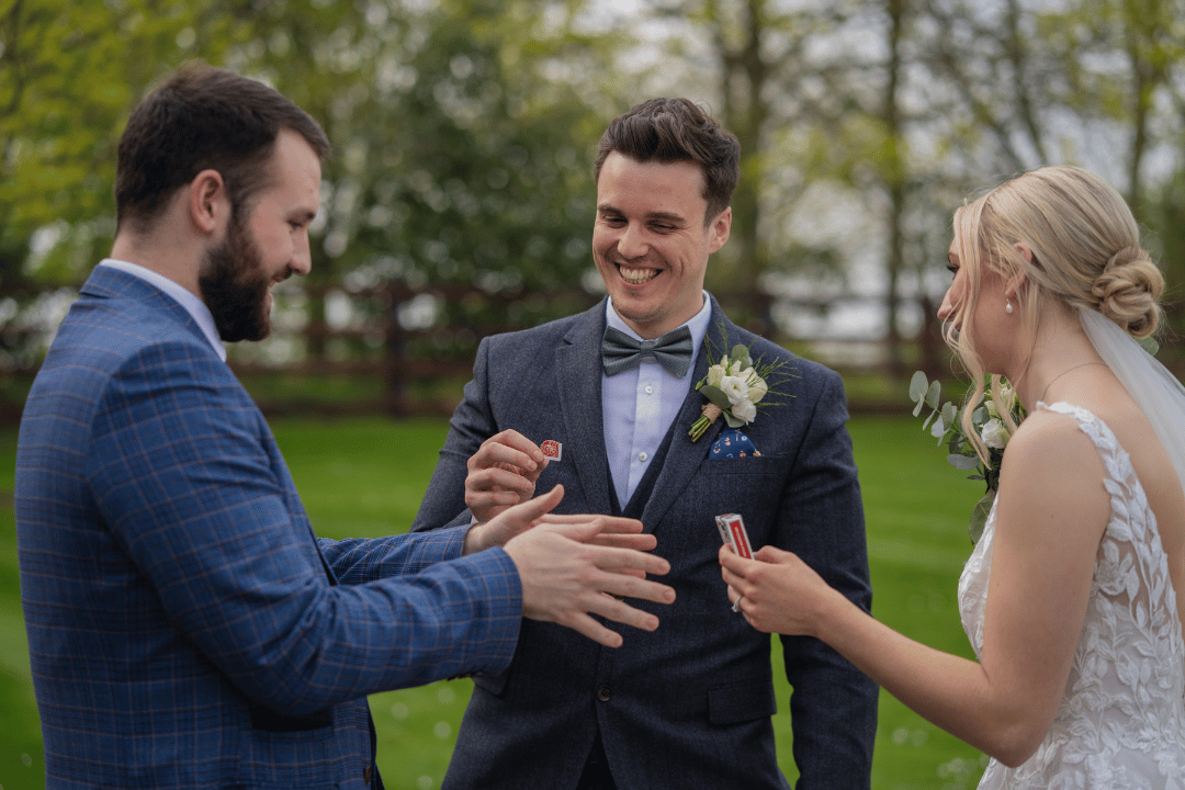 Northampton wedding magician and wedding host revilo twist, performs magic tricks on wedding guests. Bride and groom laugh and smile in amazement.