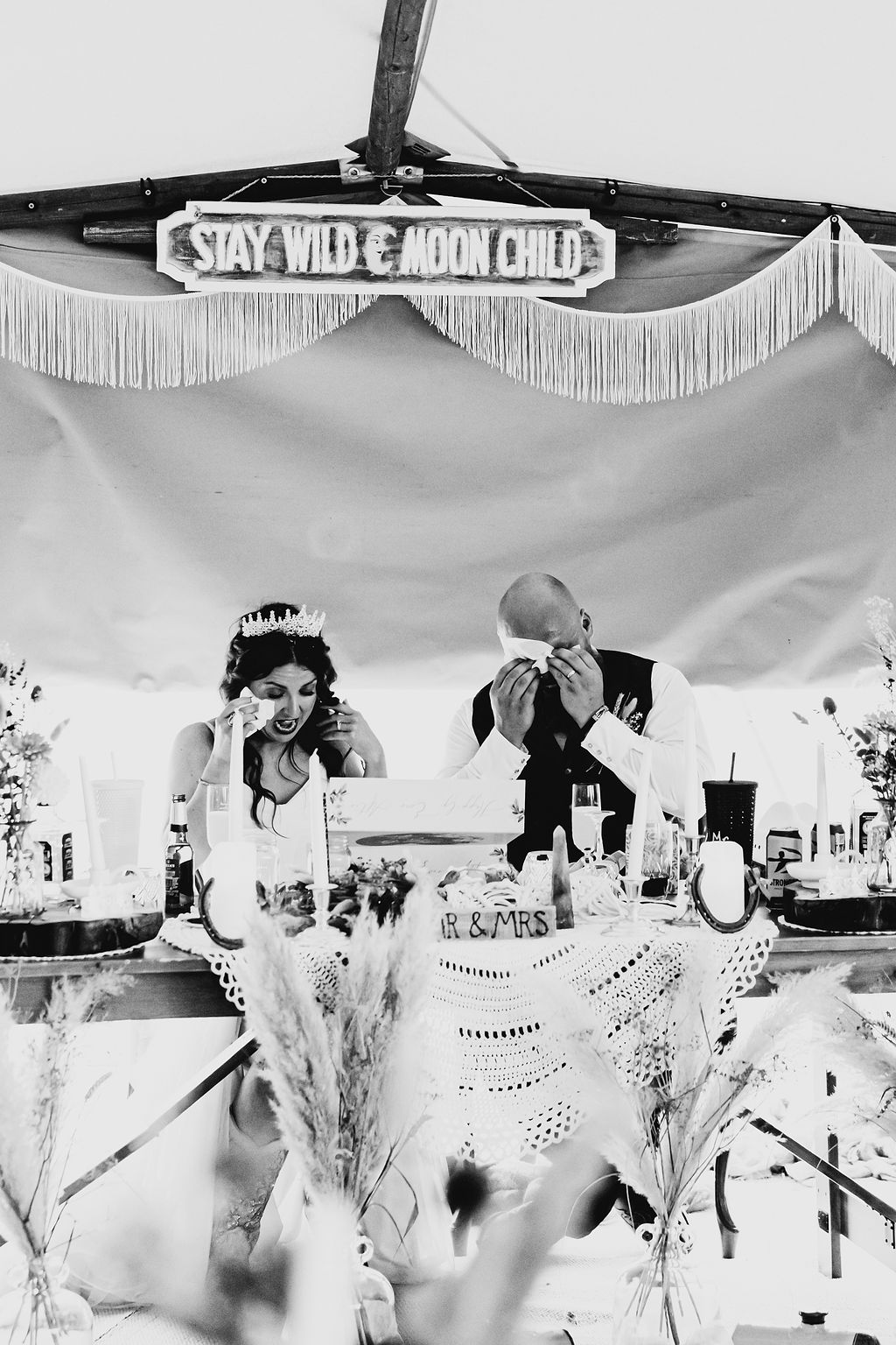 bride and groom opening wedding gift both wiping their eyes as crying