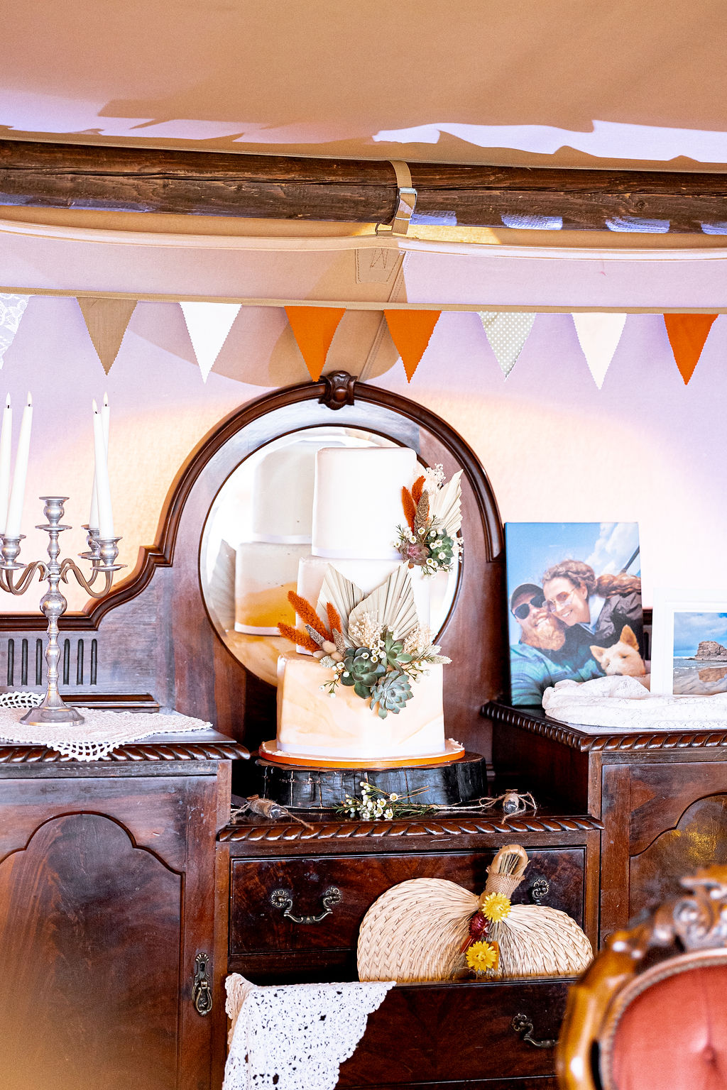 vintage dressing table with rustic wedding cake with dried flowers and succulents for western wedding