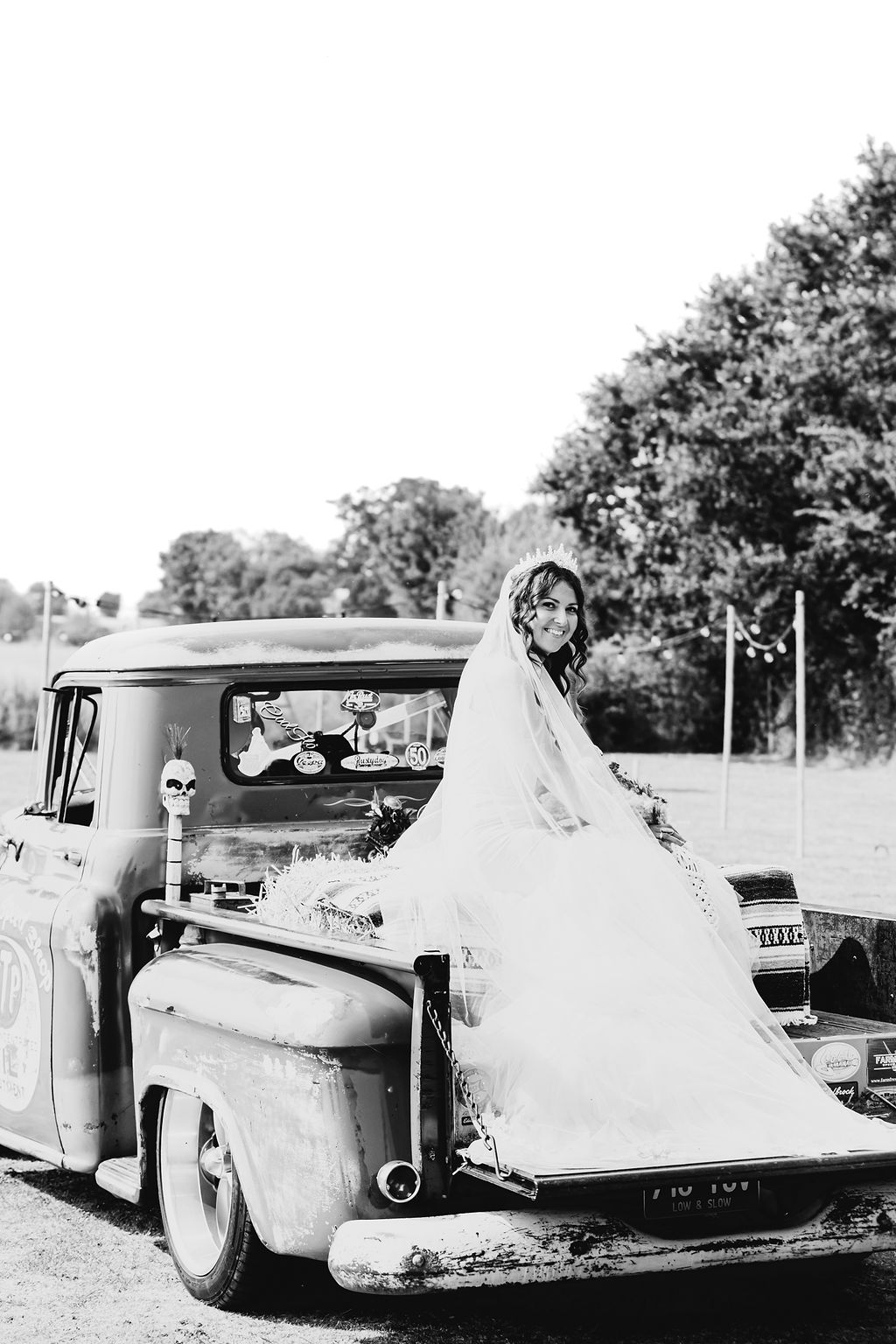 bride on the back of a Chevy truck on her way to her outdoor American Dream Western Wedding
