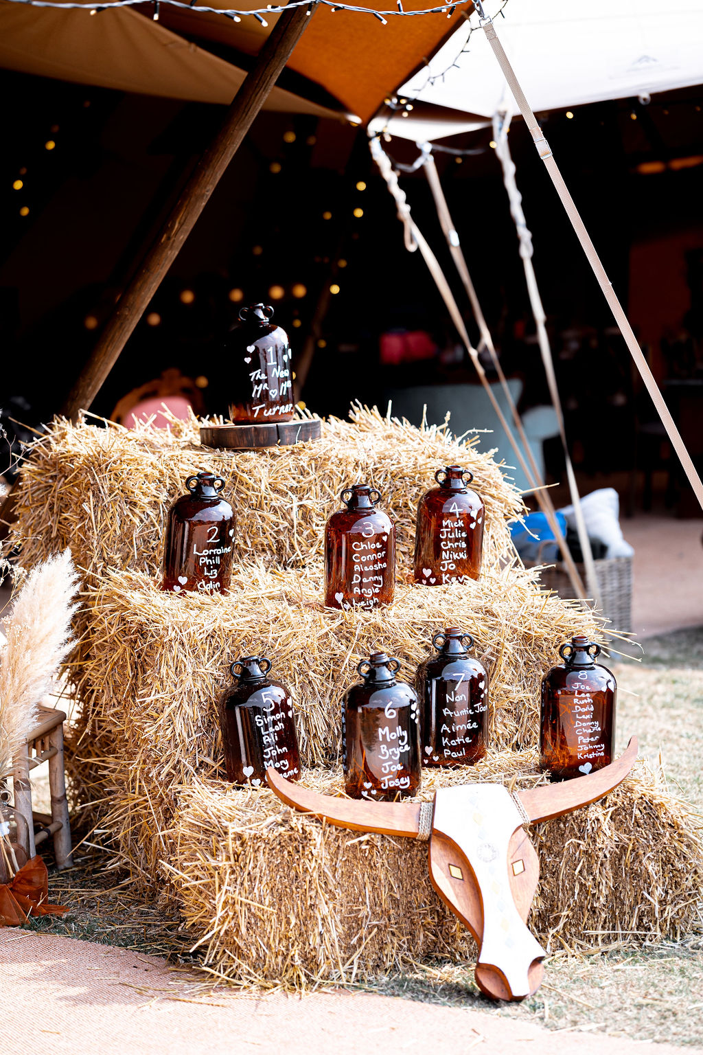 detail shot of demijohn table seating plan for western cowboy wedding