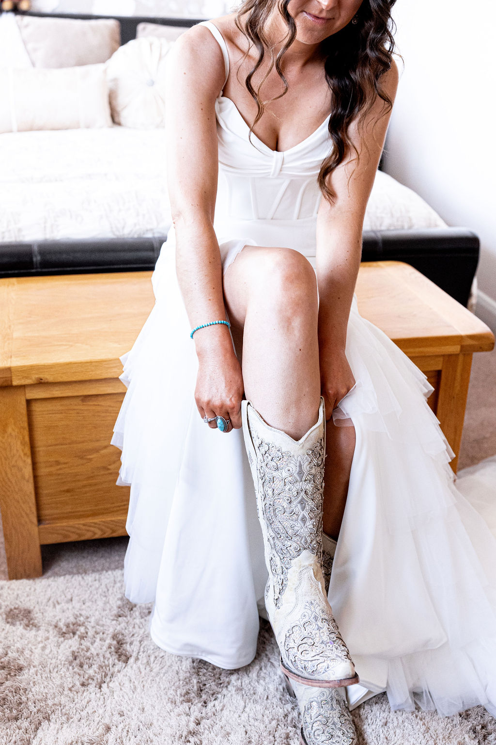 detail shot of bride putting her cowboy boots on for American Dream Western Wedding