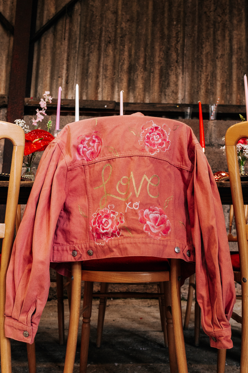 hand painted pink denim jacket on the back of a chair