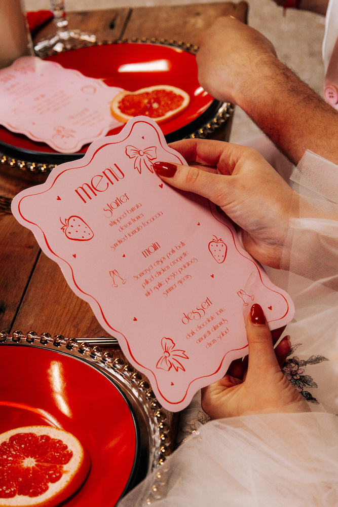 detail shot of playful red and pink wedding breakfast menu