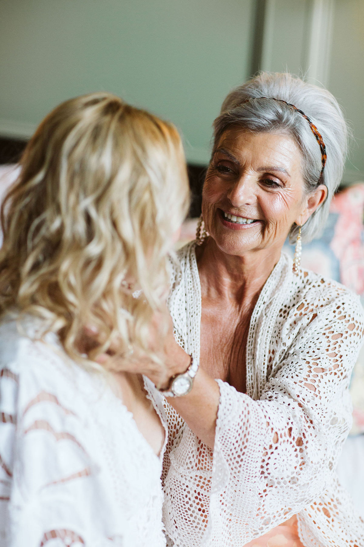 mother stroking hte side of the brides face before the wedding ceremony. Touching photo showing the mother-daughter connection