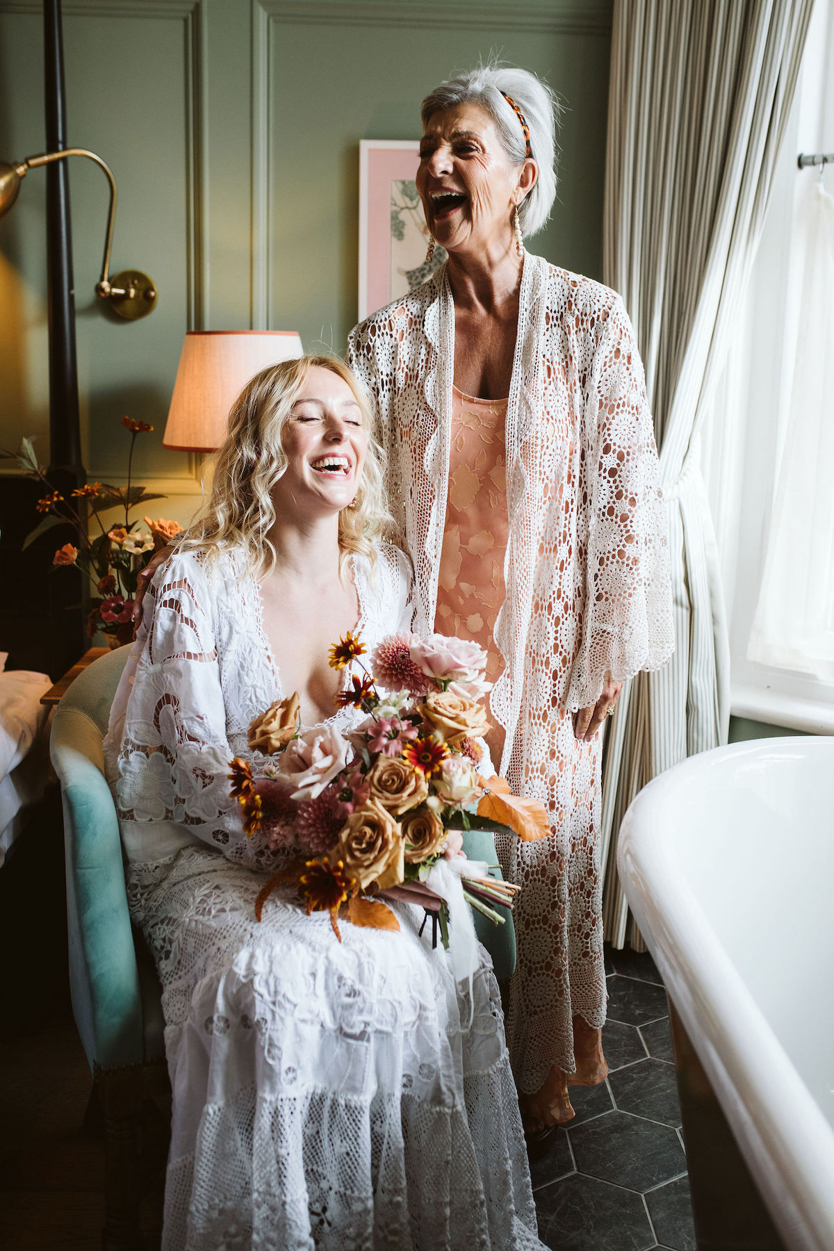 mother and daughter laughing together on the morning of the wedding day