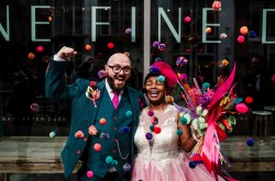 alternative bride and groom celebrate after getting married, bride wears a pink coloured wedding dress.