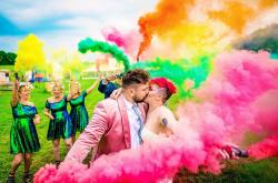 alternative bride and groom kiss in a multi coloured smoke bomb shot