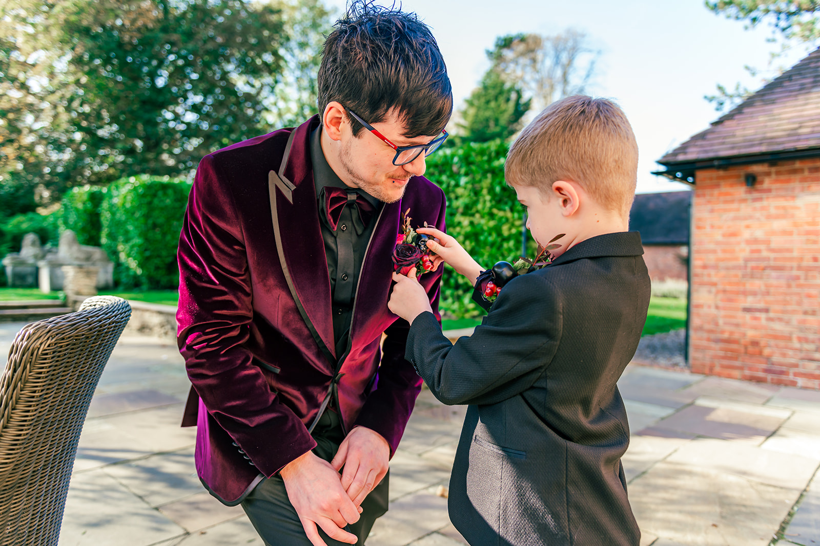 photo of the groom's son who is the best man attaching the button hole to his jacket
