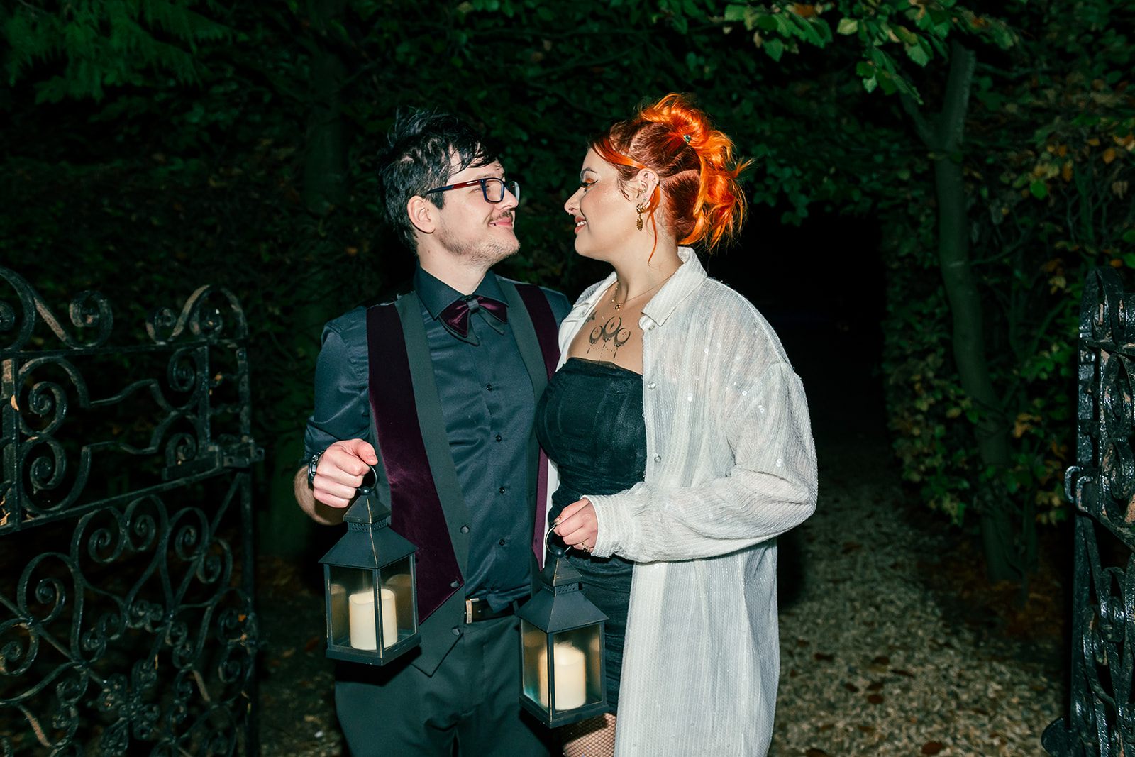 bride and groom outside of the wedding venue at night holding lanterns