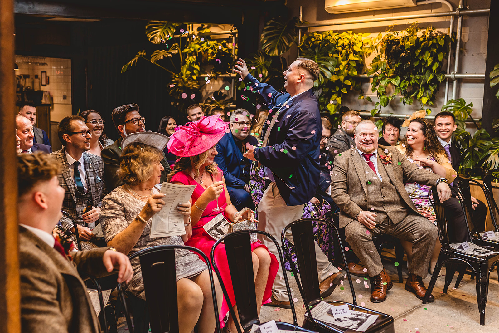 wedding guest entertains others while showering confetti on them before the start of the wedding ceremony