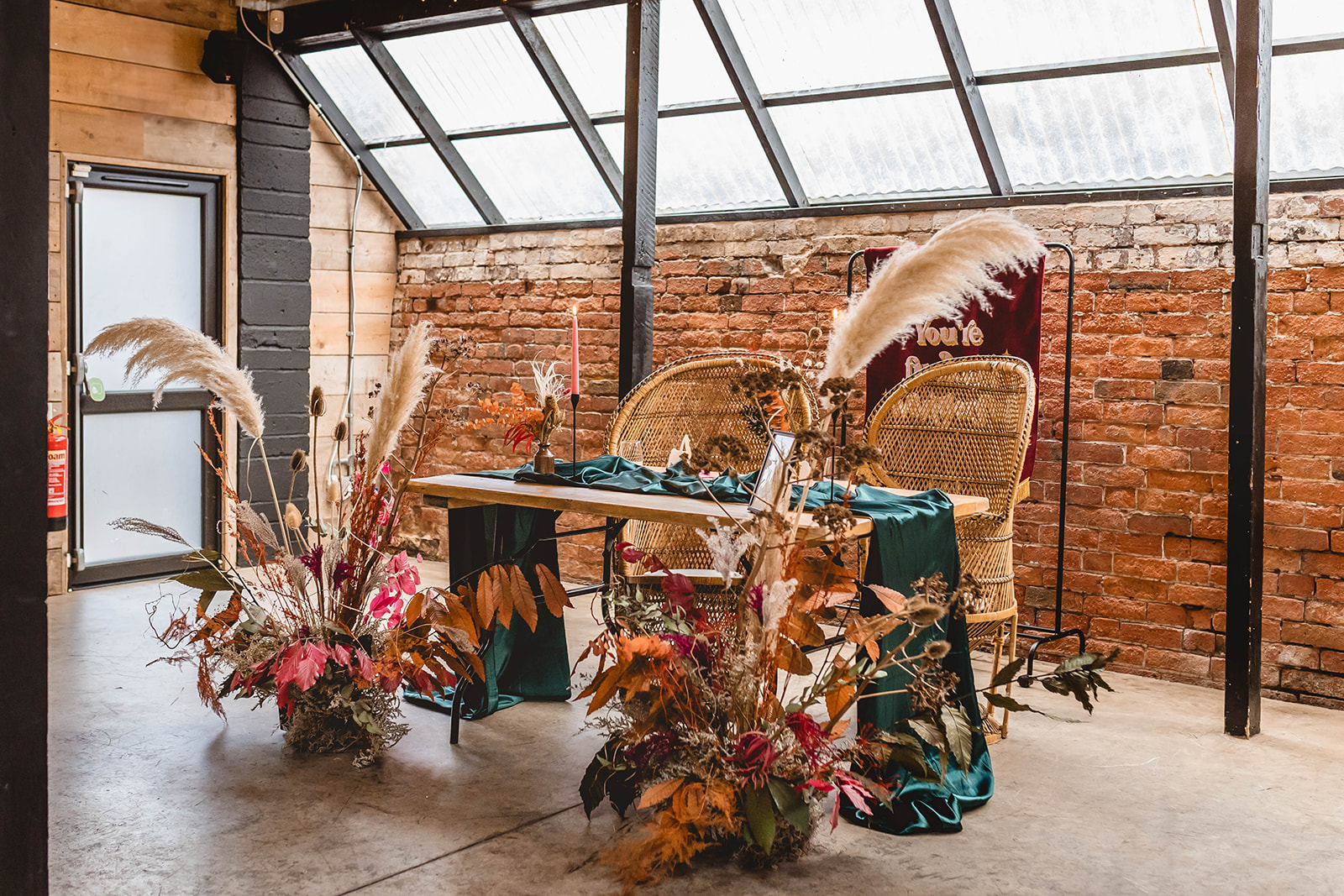 details shot of bride and grooms wedding breakfast table set up with peacock chairs and dried flowers in autumnal colours as part of a wedding full of personality