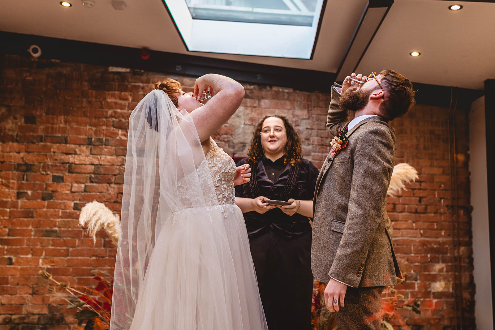 couple downing shots as part of their wedding ceremony