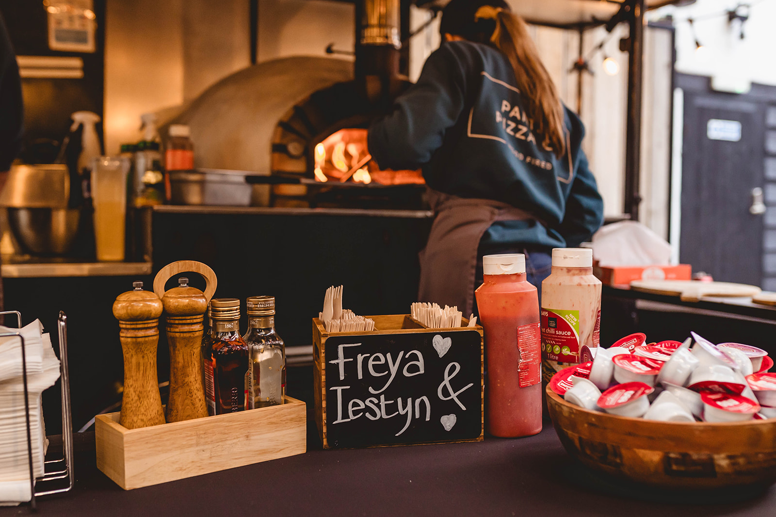 woman firing pizza in wood fire oven for wedding breakfast