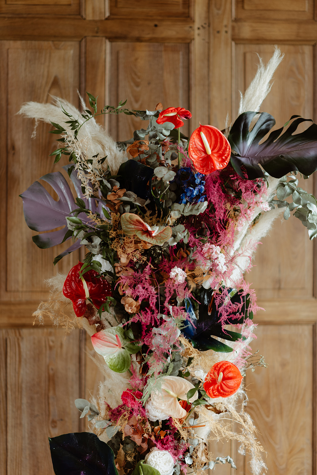 detail shot of unconventional flower arrangement for wedding ceremony. It contains a mix of red, blue and whit flowers