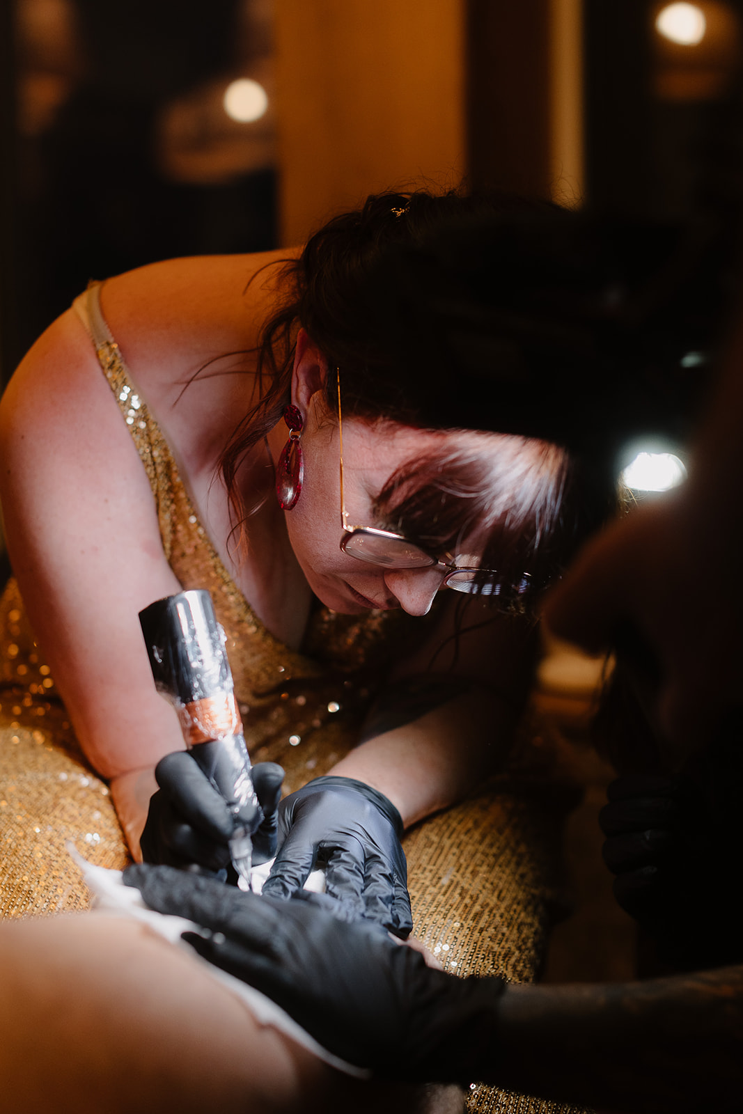 detail shot of a bride giving her husband a tattoo at the unconventional evening reception of their wedding