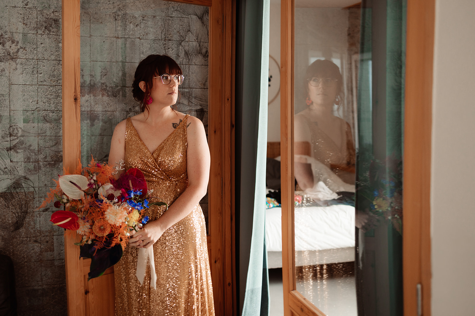 Bridal portrait of a bride wearing a gold wedding dress, holding a bright wedding bouquet