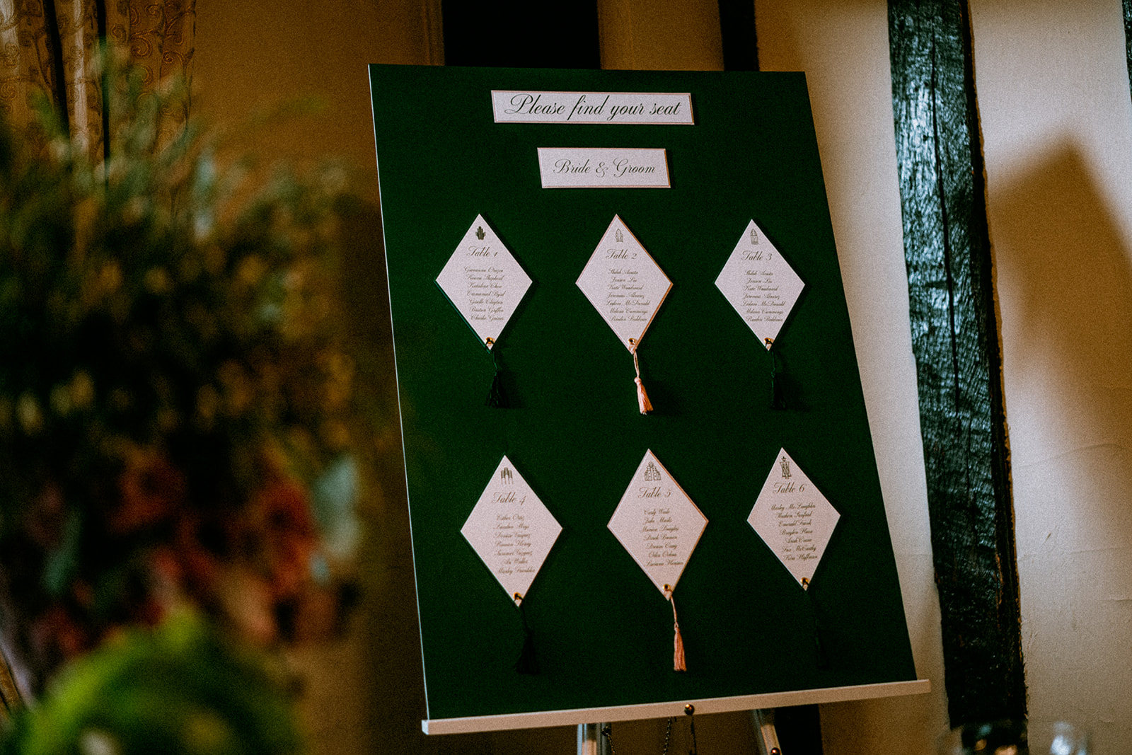Emerald green seating plan with geometric shapes and tassels as part of a Wicked inspired wedding