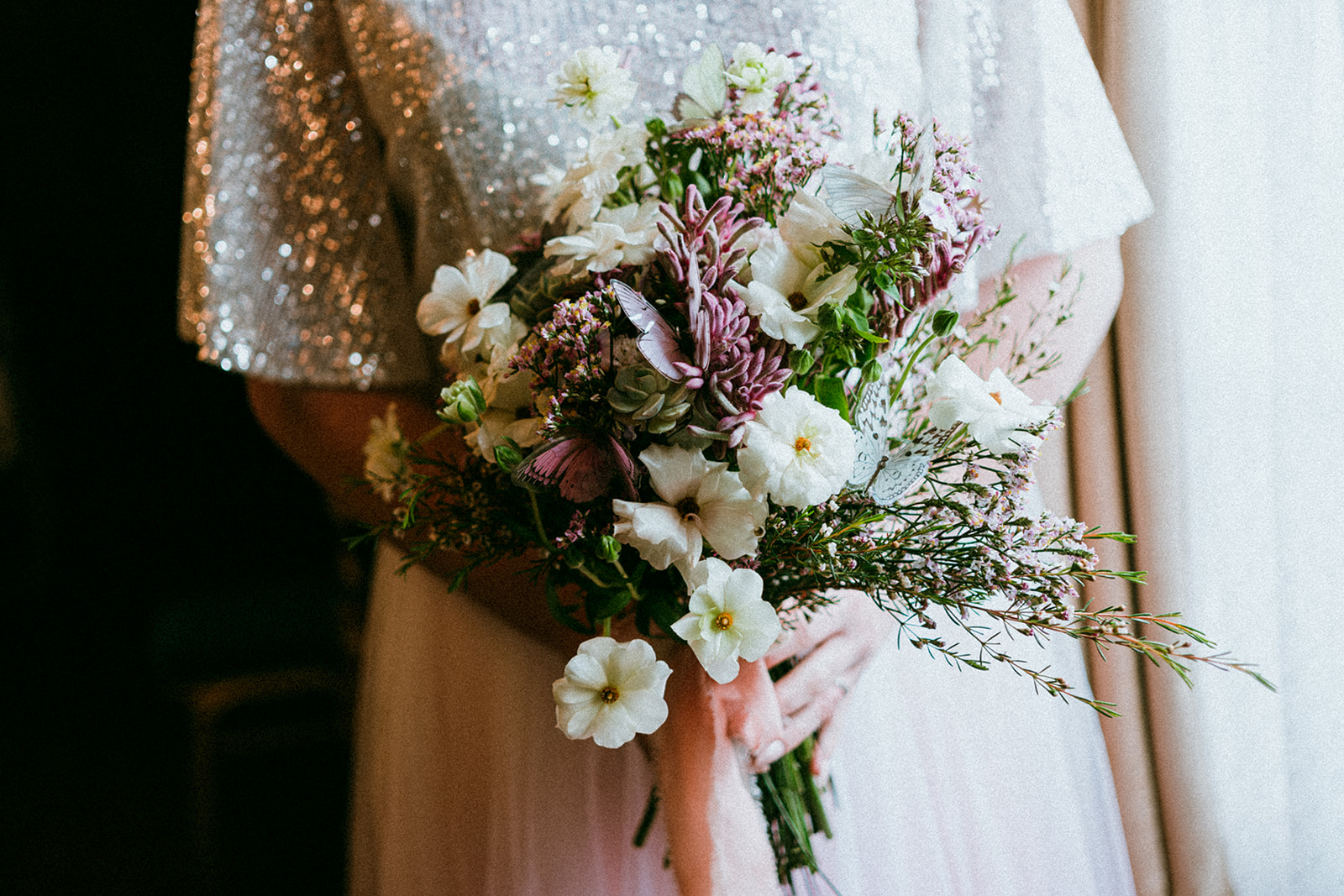 Detail shot of white and pink whimsical bridal bouquet with butterflies