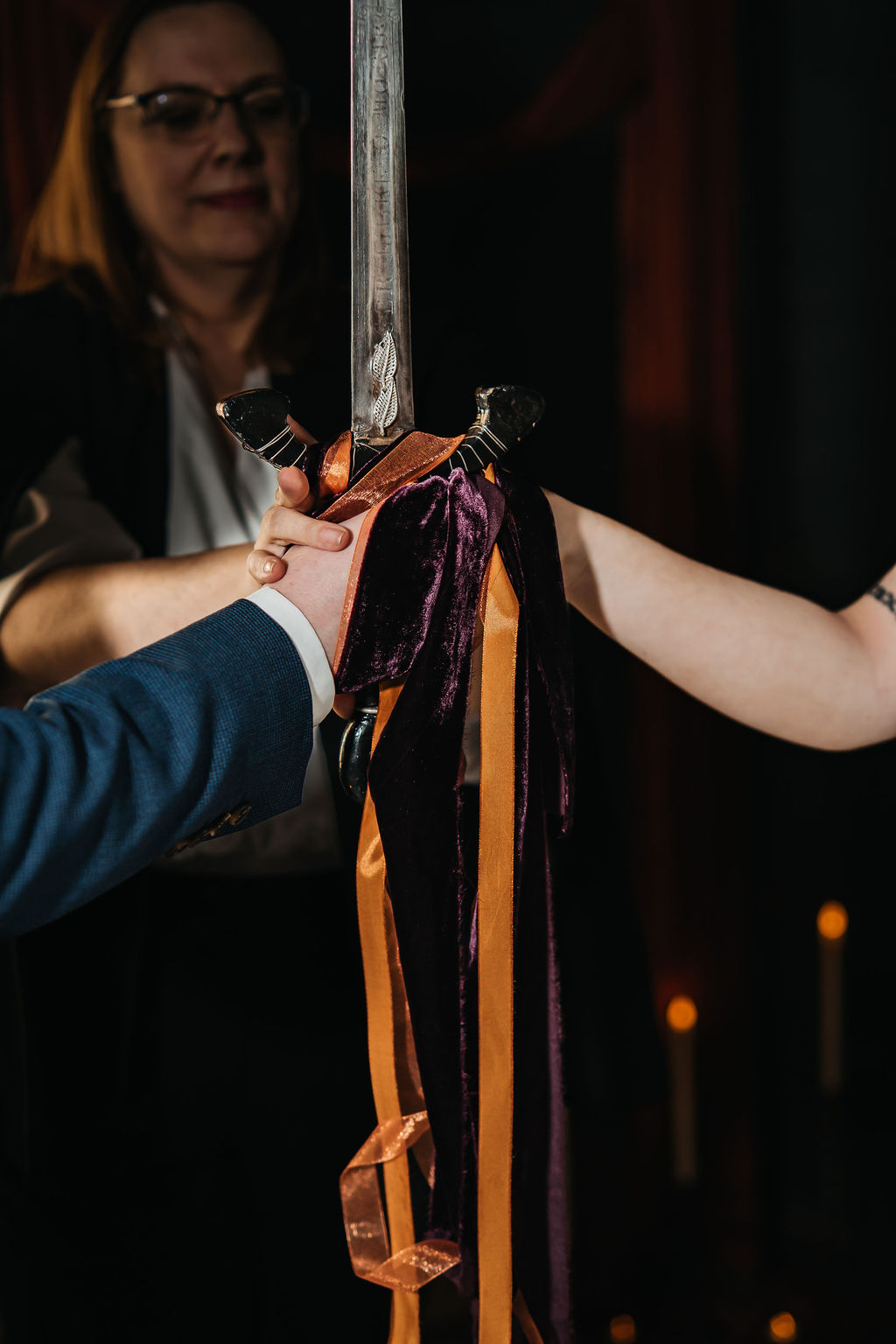 Detail shot of the hands bound by ribbons around a sword as part of a viking sword ceremony